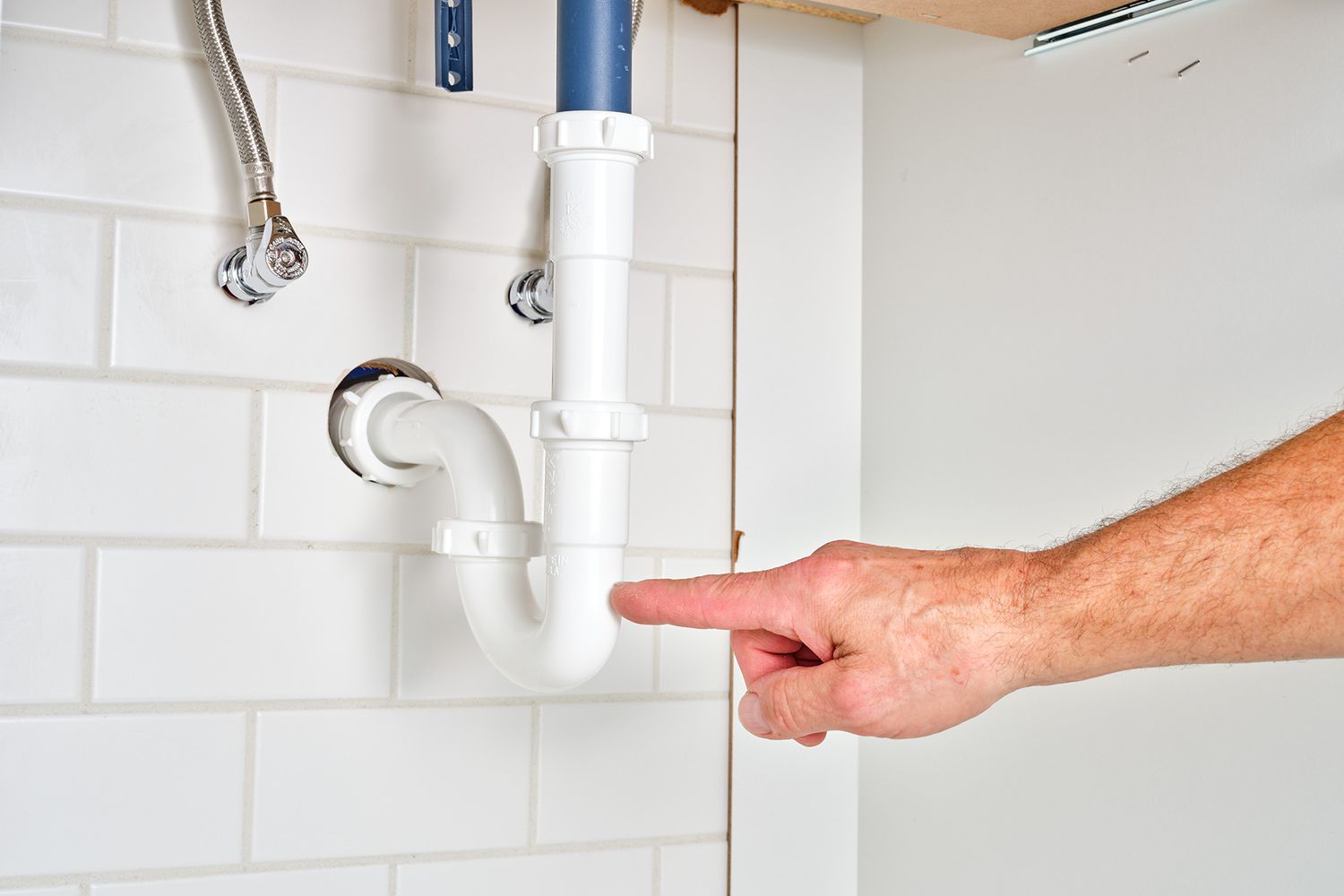 P-trap pipe being checked for leaks under sink