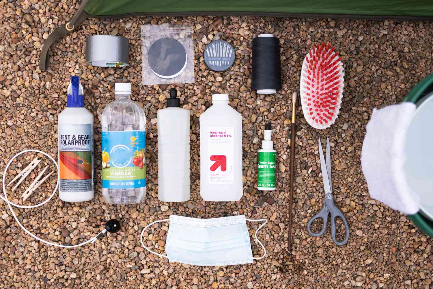 Matériel et outils pour nettoyer une tente sur un sol de gravier brun