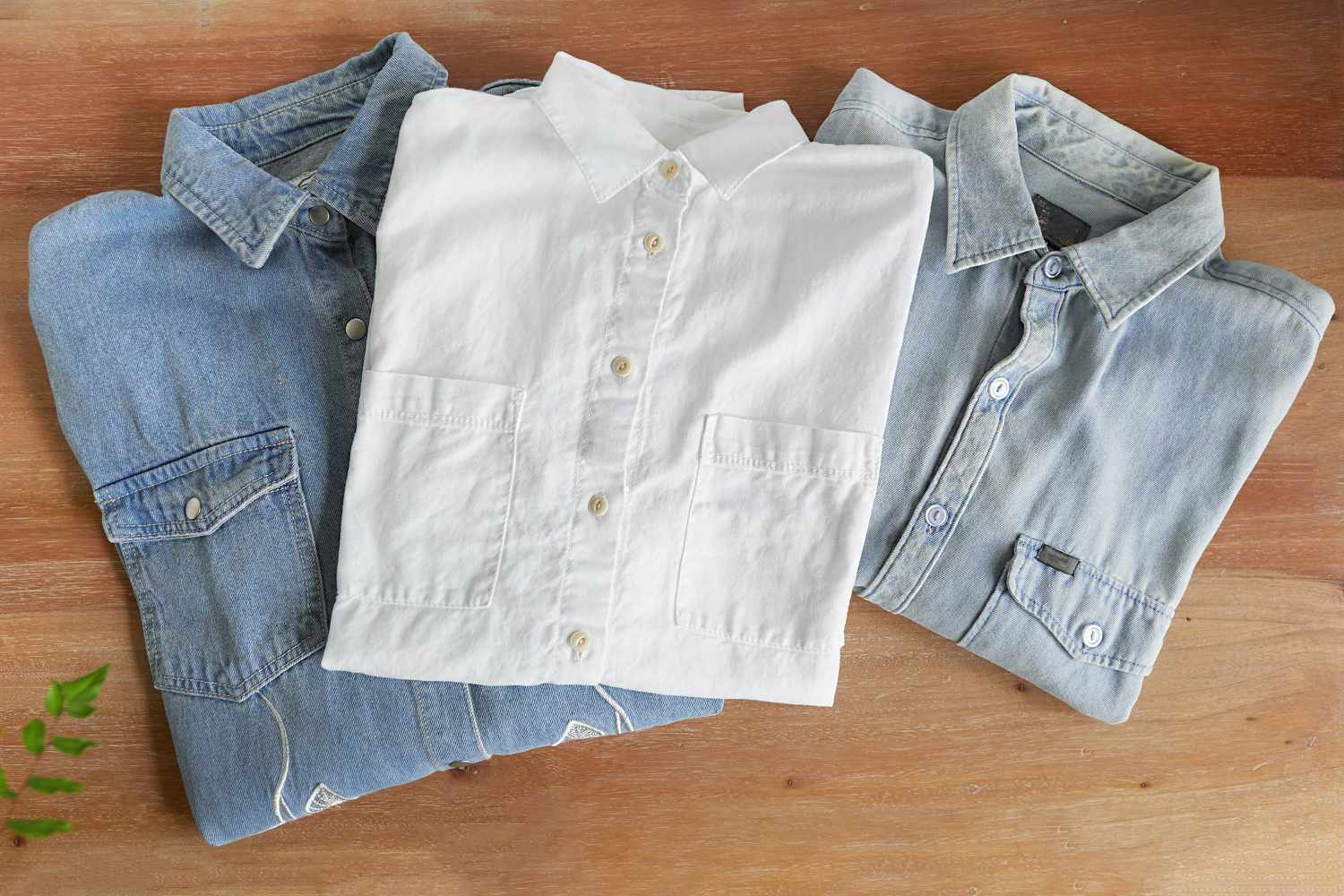 Jeans und weiße Button-down-Hemden gefaltet auf Holzunterlage