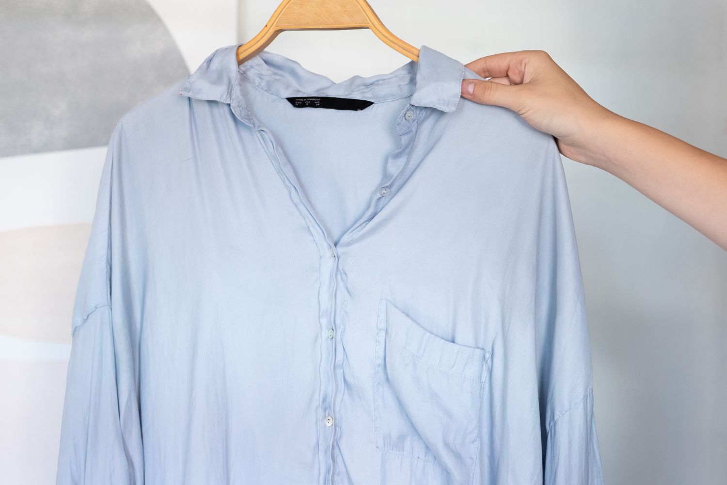 Blaues Polyesterhemd gebügelt und zum Lufttrocknen aufgehängt