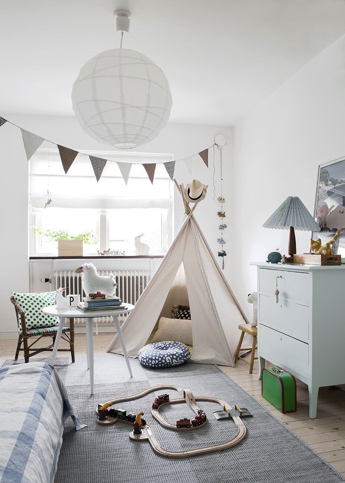 Bright and airy nursery with dramatic light fixture, large windows, and lots of natural light
