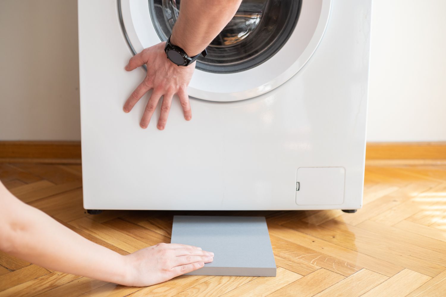 Two-by-four gray block slided in front of washing machine