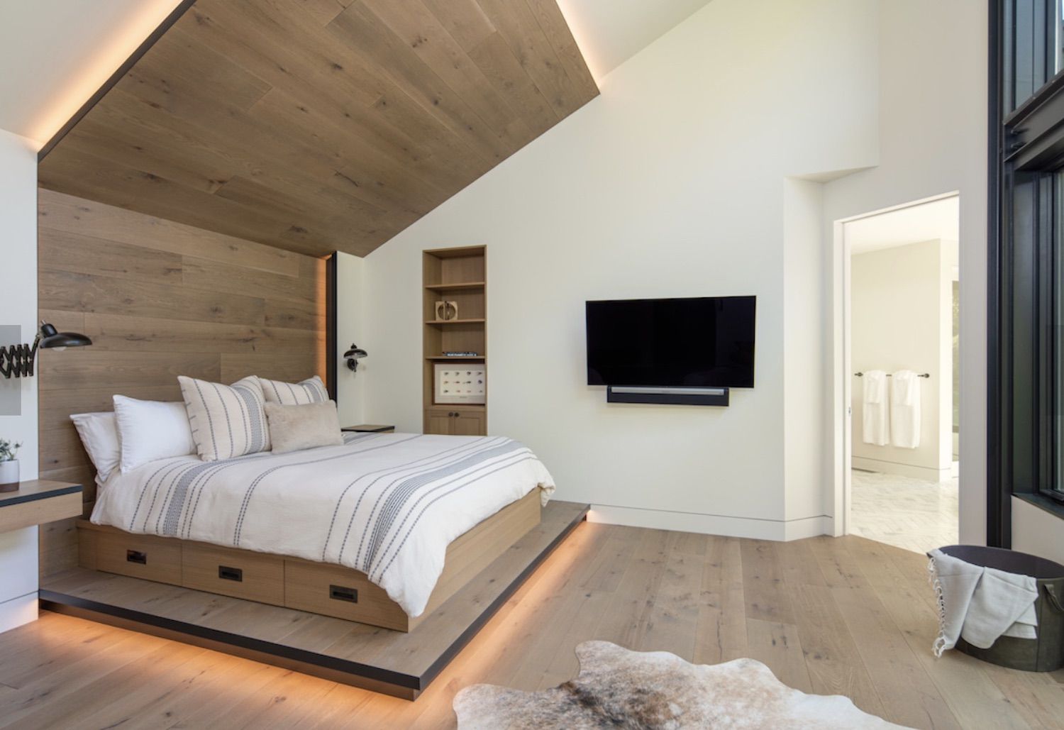 modern bedroom with wooden light accent wall and bed frame, wooden floor, open floorplan