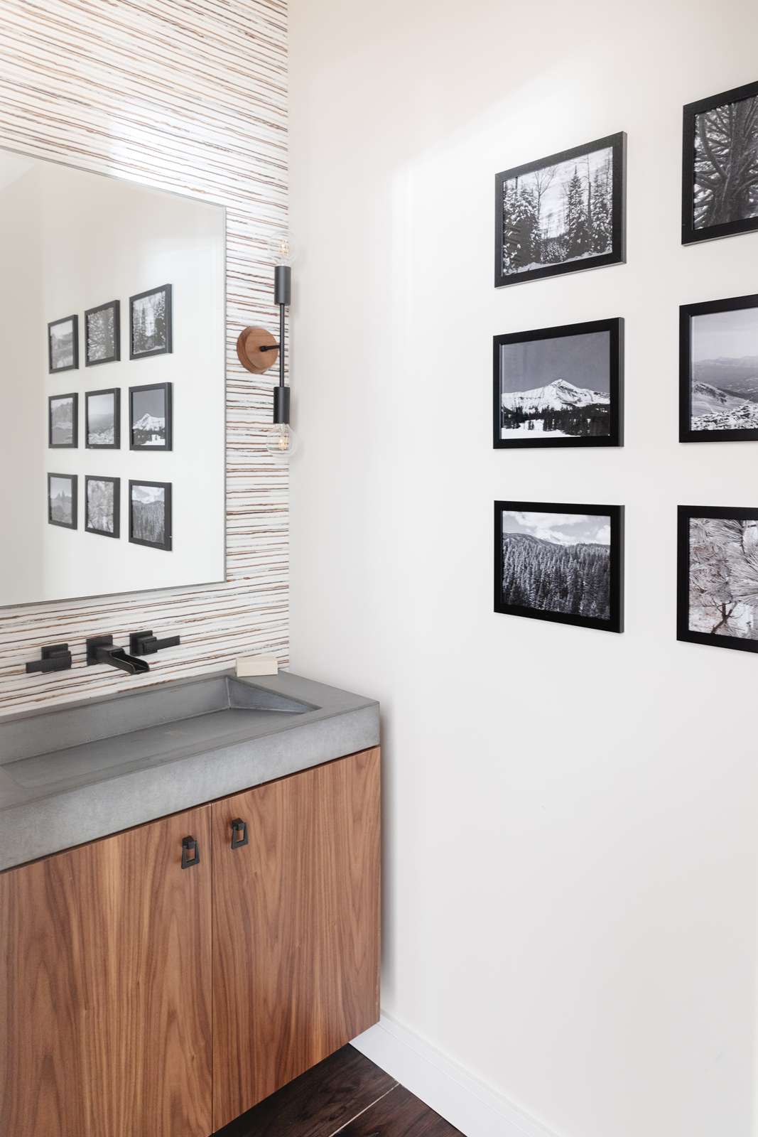 Uma parede de galeria em preto e branco em um banheiro