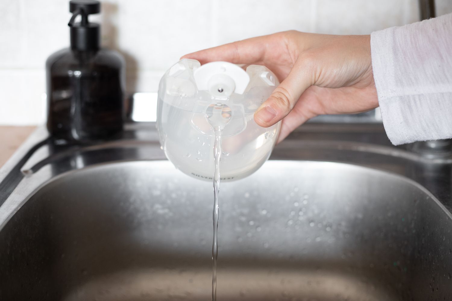 Réservoir d'eau du défroisseur à linge vidé dans l'évier