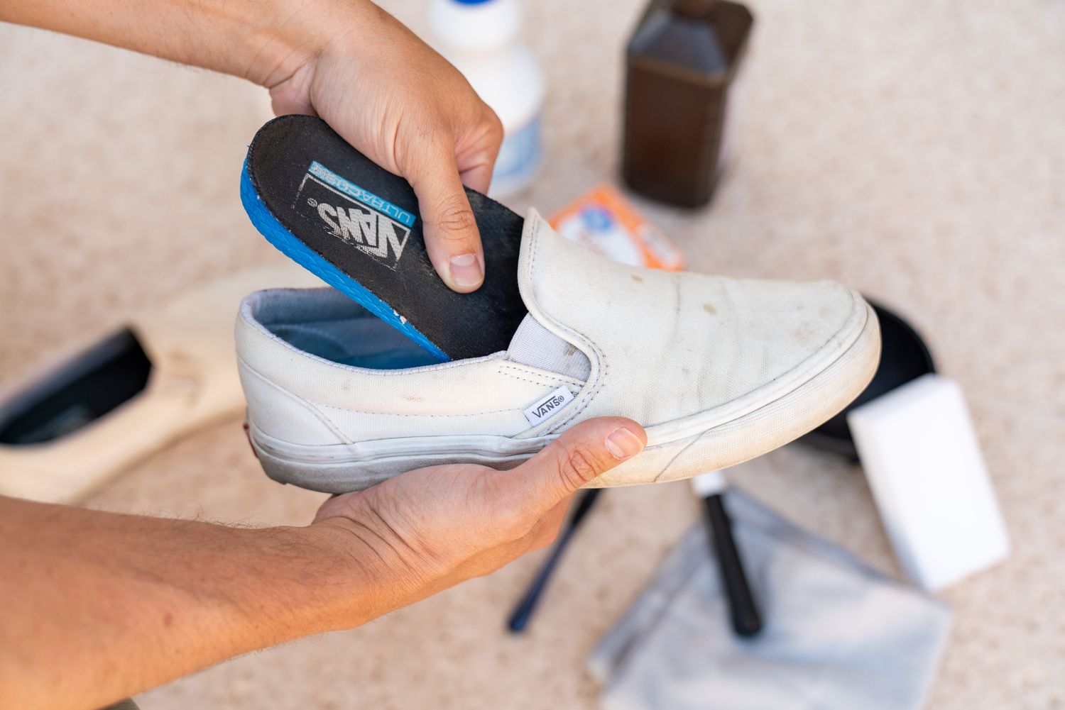 Insoles being removed from dirty white vans