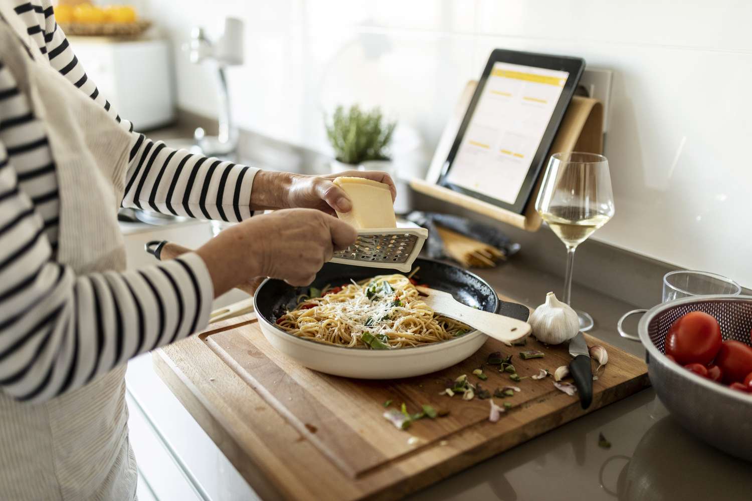 Eine Frau reibt Käse und kocht.