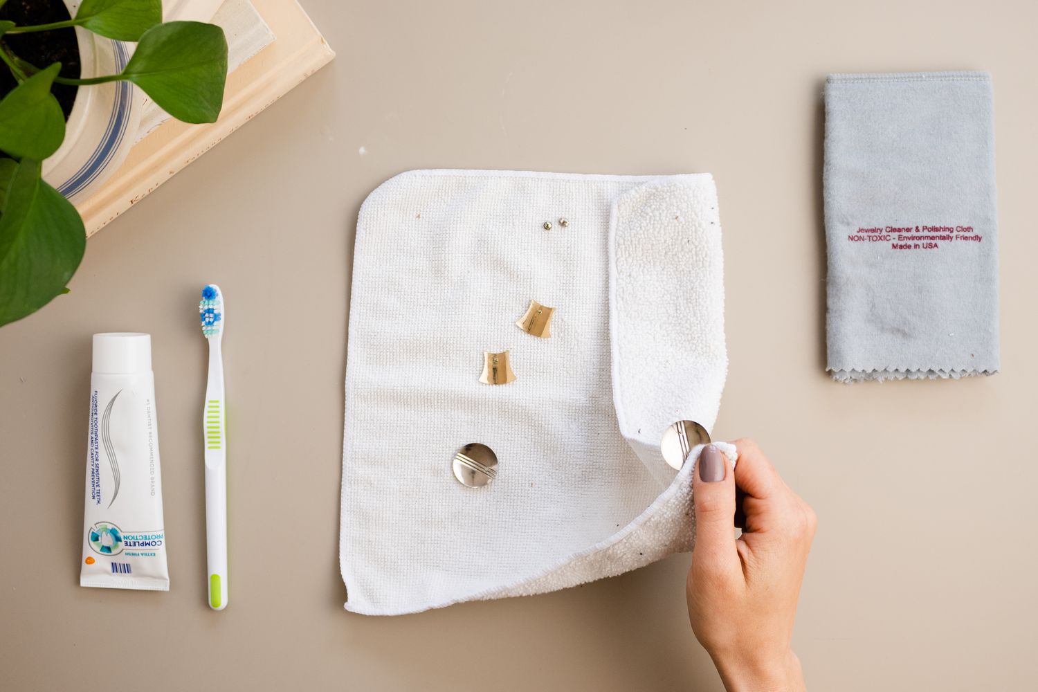 Joias de aço inoxidável sendo secas dentro de um pano de microfibra branco