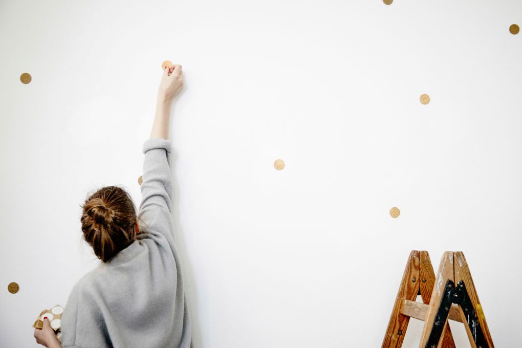 Mujer decorando pared