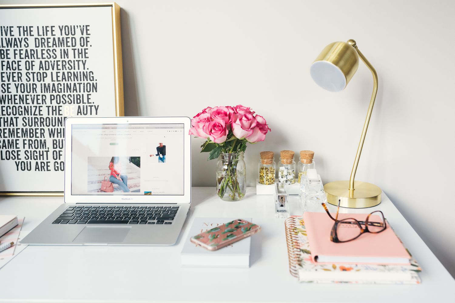 colorful workspace with rose, artwork, and laptop