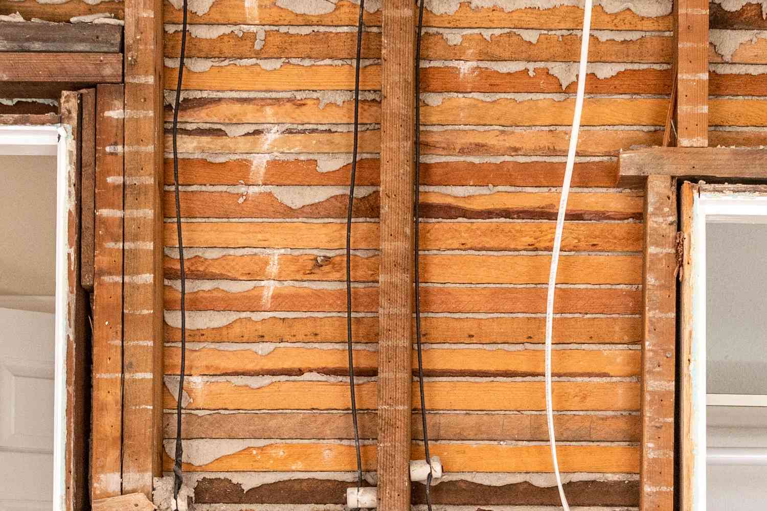 Lath and plaster walls exposed in home renovation with wires hanging