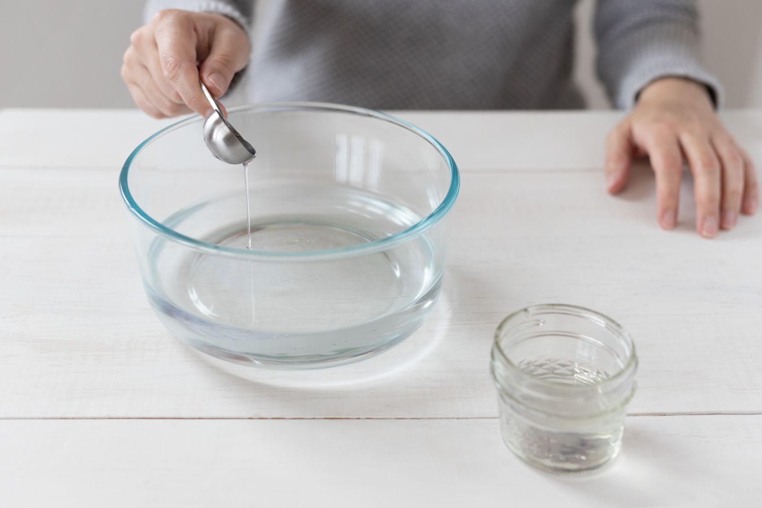 Geschirrspülmittel in einer Glasschüssel mit Wasser für eine Reinigungsmischung