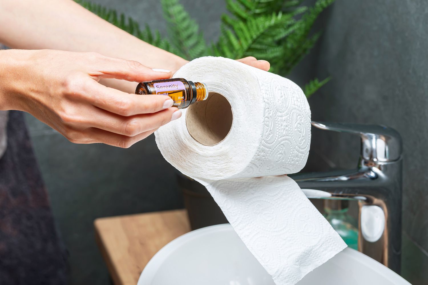 Hinzufügen von ätherischem Öl auf die Innenseite einer Toilettenpapierrolle