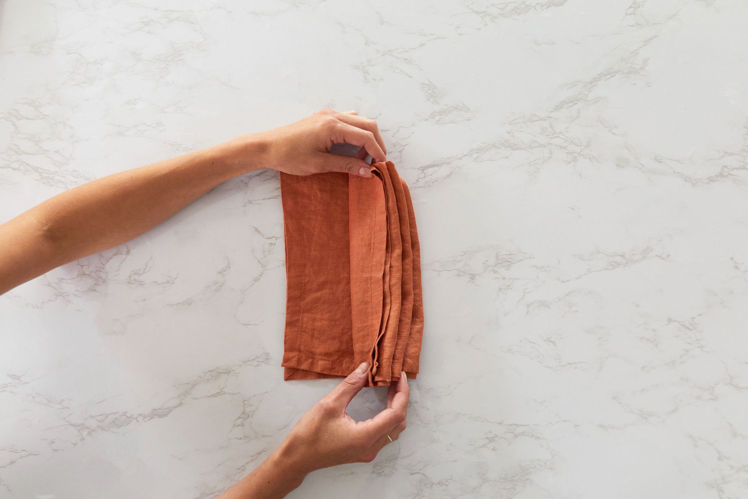 Orange cloth napkin folded horizontally like an accordion