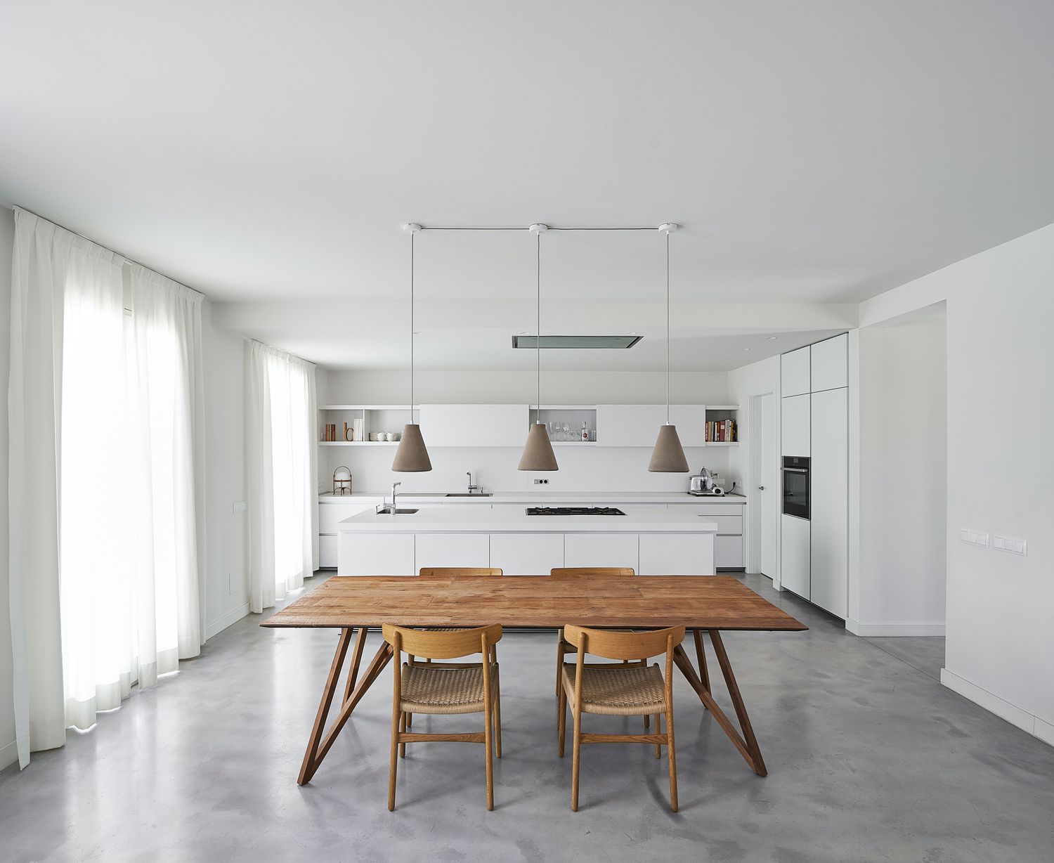 cocina minimalista blanca con mesa de madera