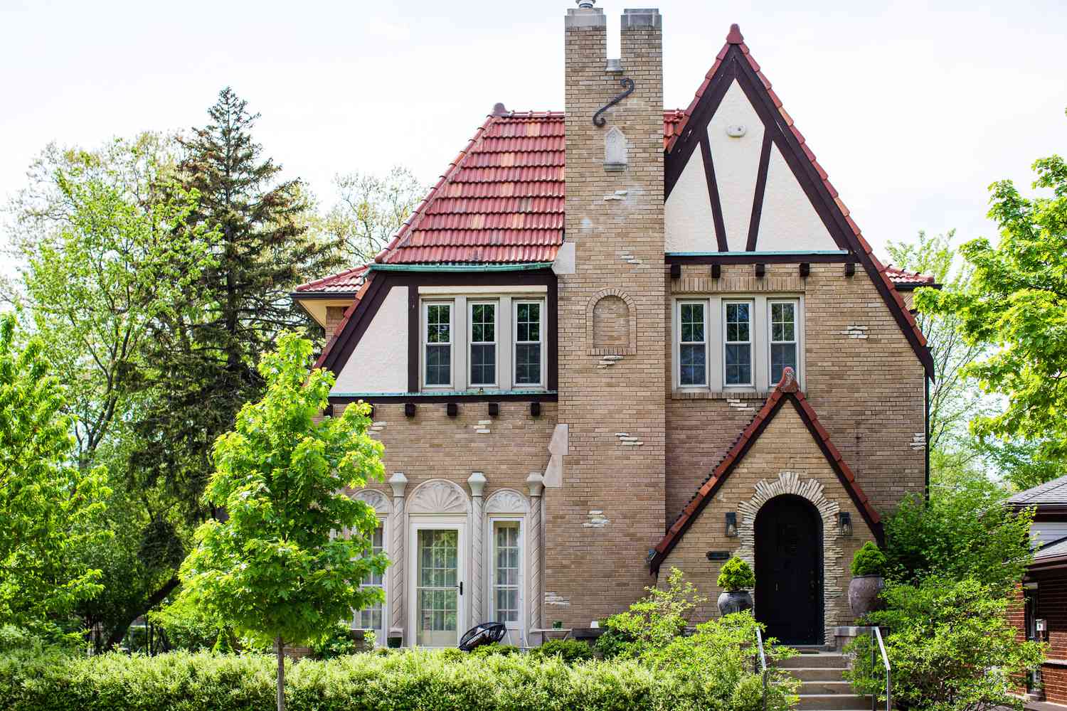 Tudor-Revival-Haus mit Ziegelwänden und Schornstein mit steilem Dach