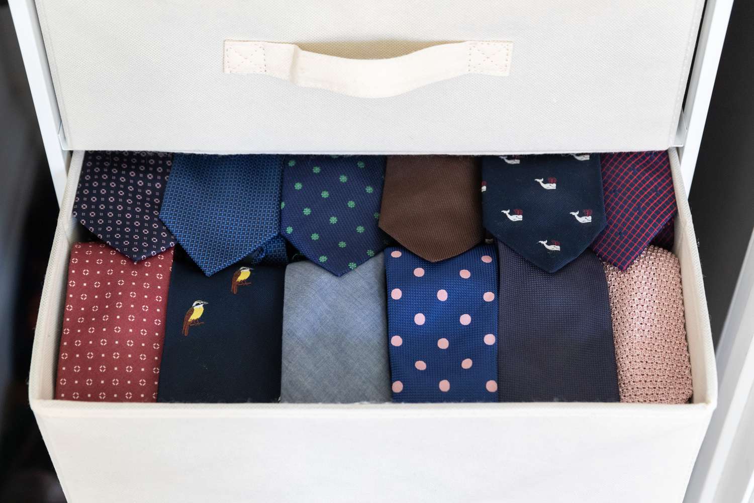 Neckties rolled and stored in white drawer