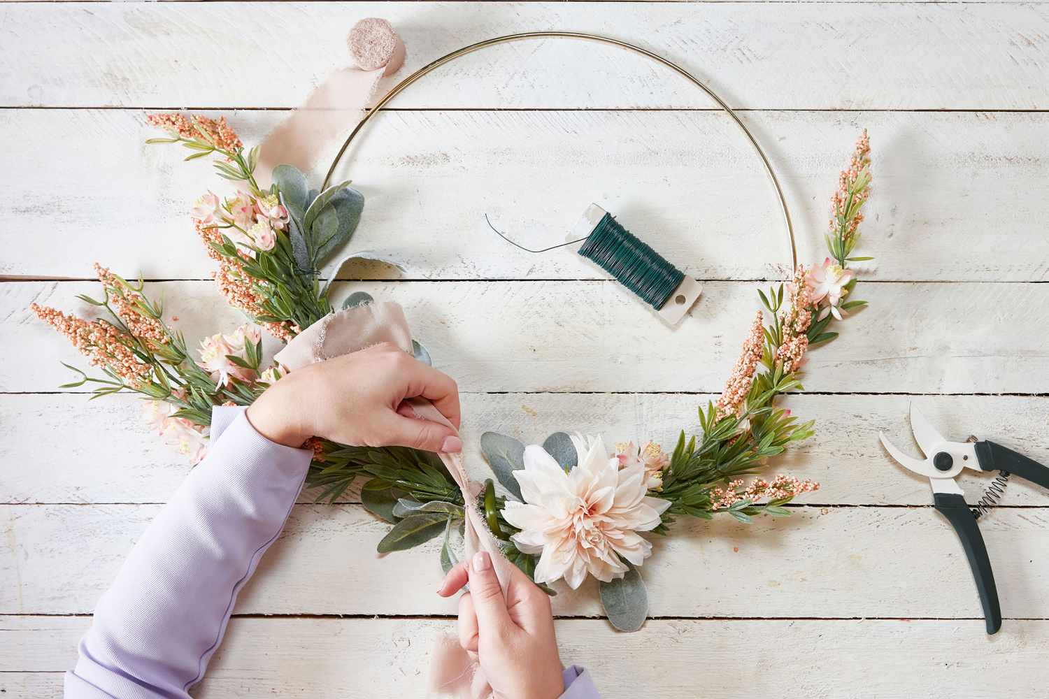 Hand tying ribbon on wreath