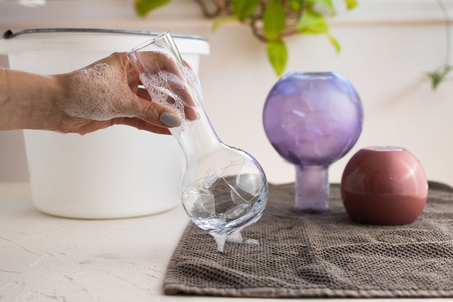 Vaso de vidro alto limpo com água e sabão e colocado em um pano marrom