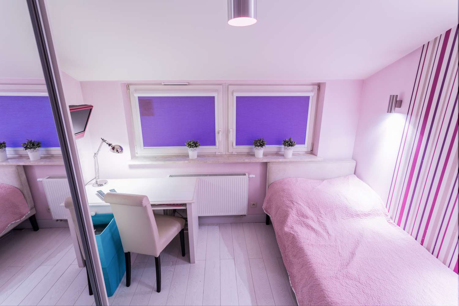 Papel pintado a rayas rosas y moradas en la habitación de una adolescente.