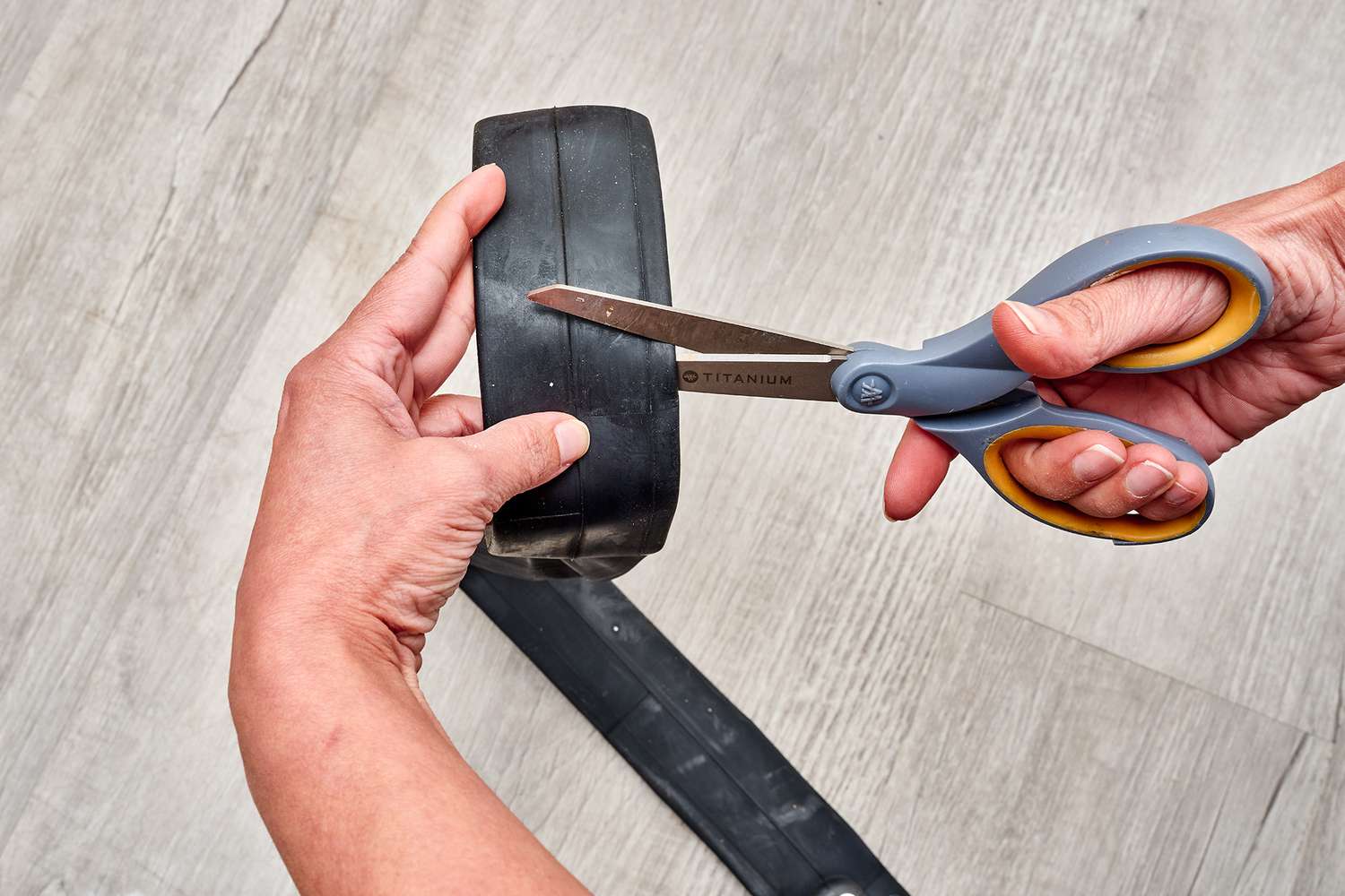 Borracha sendo cortada com uma tesoura para remendar um cano de PVC