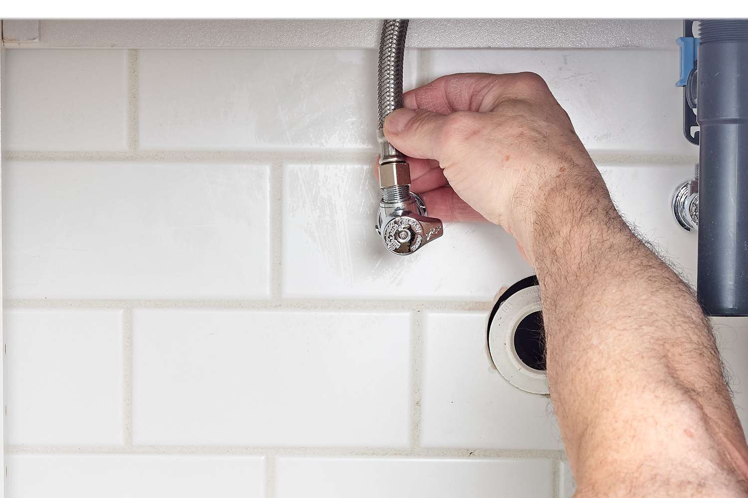 Linhas de abastecimento de água conectadas à parte inferior da torneira da pia e ao ralo