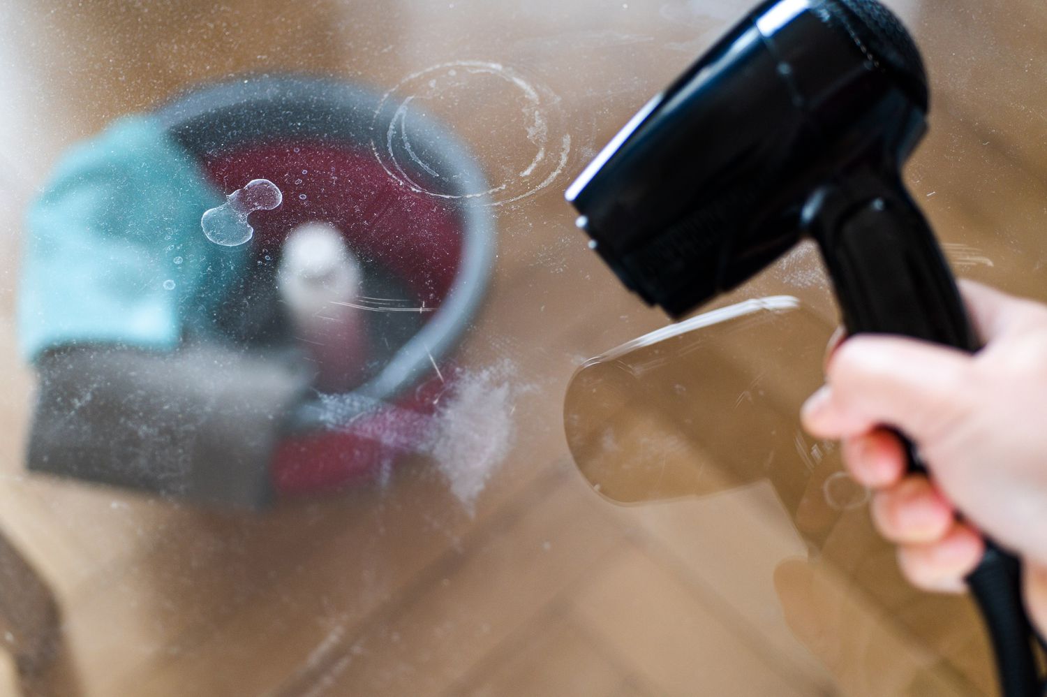 Hair dryer blowing dust of acrylic surface with water marks