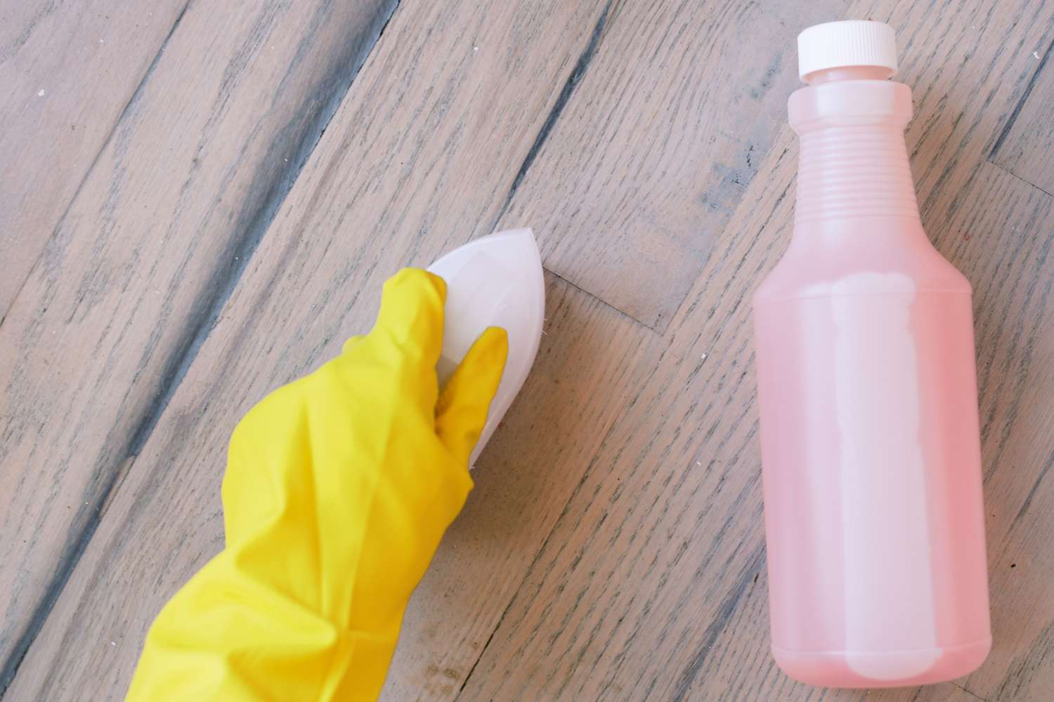 Zones moisies frottées avec du substitut de PST et une brosse dure sur un plancher en bois