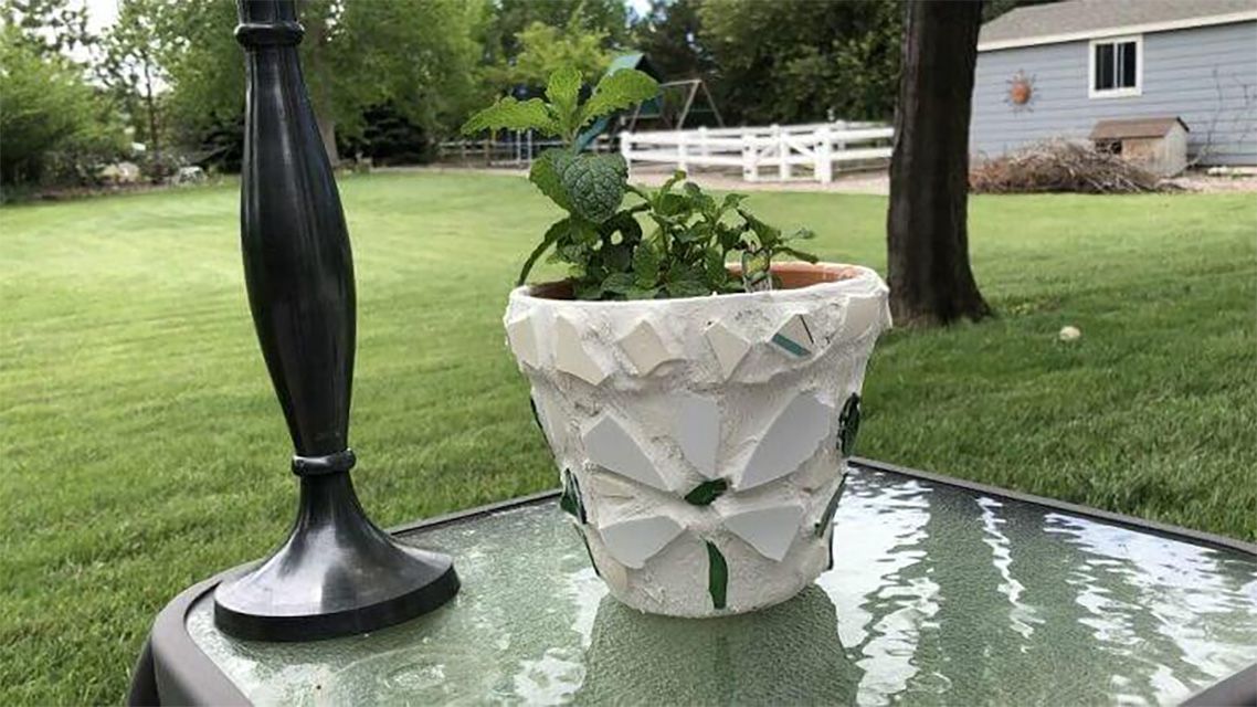 Un pot de fleurs en mosaïque blanc et vert
