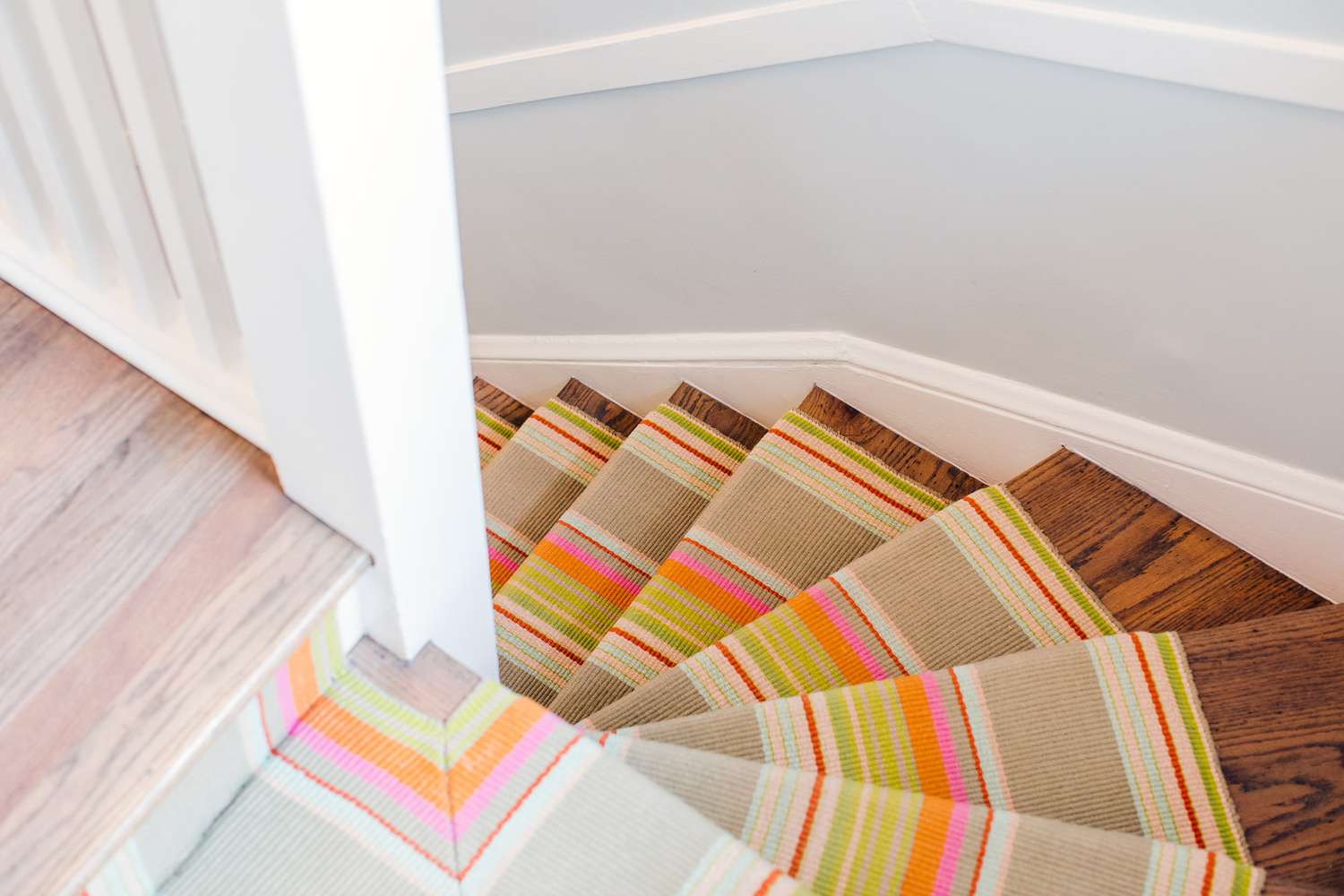 Alfombra de rayas de colores cubriendo escalera de madera
