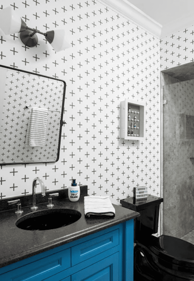 Baño con papel pintado en blanco y negro y tocador azul