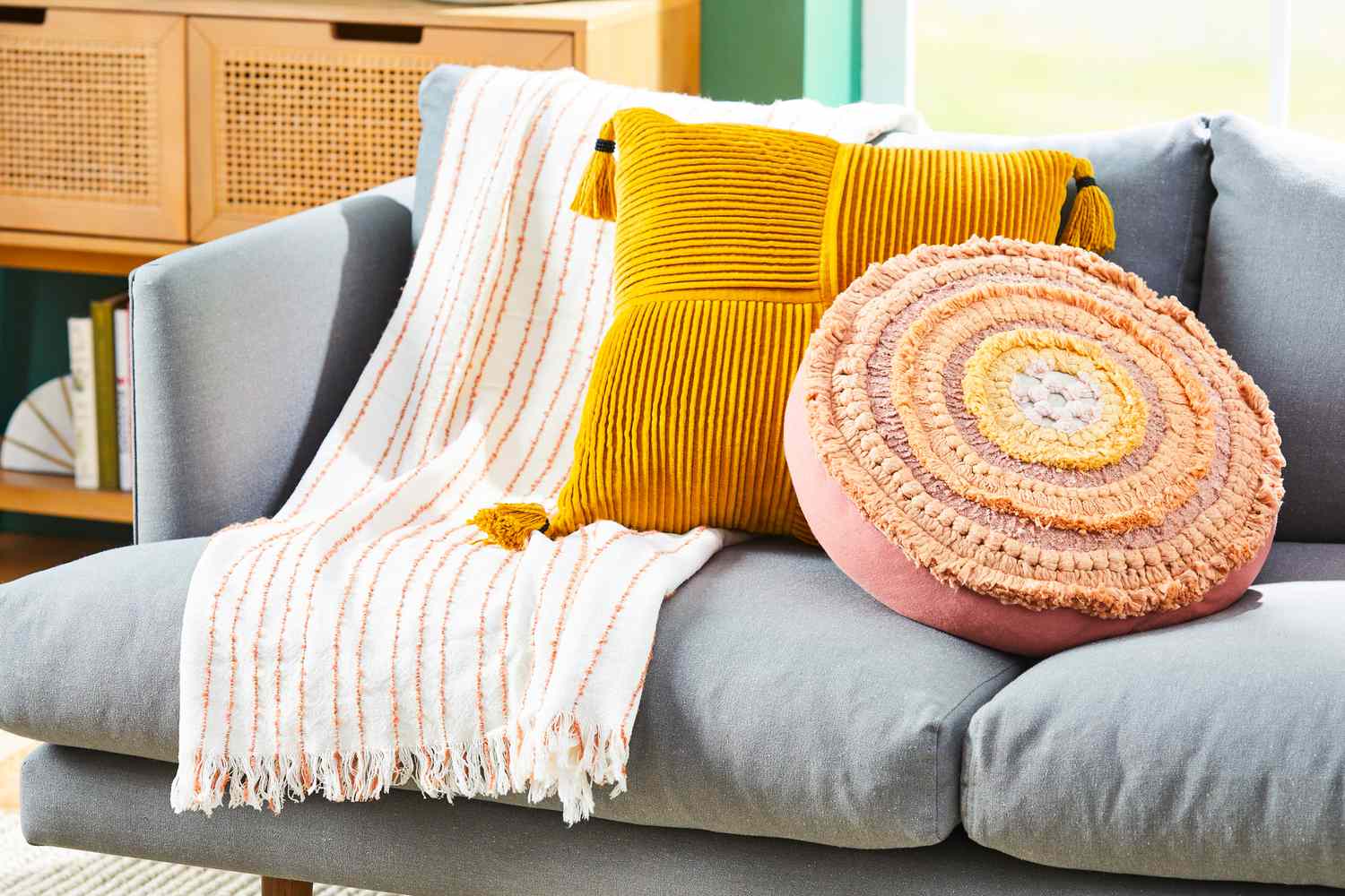 Colorful pillows and throw on a pale blue-gray sofa