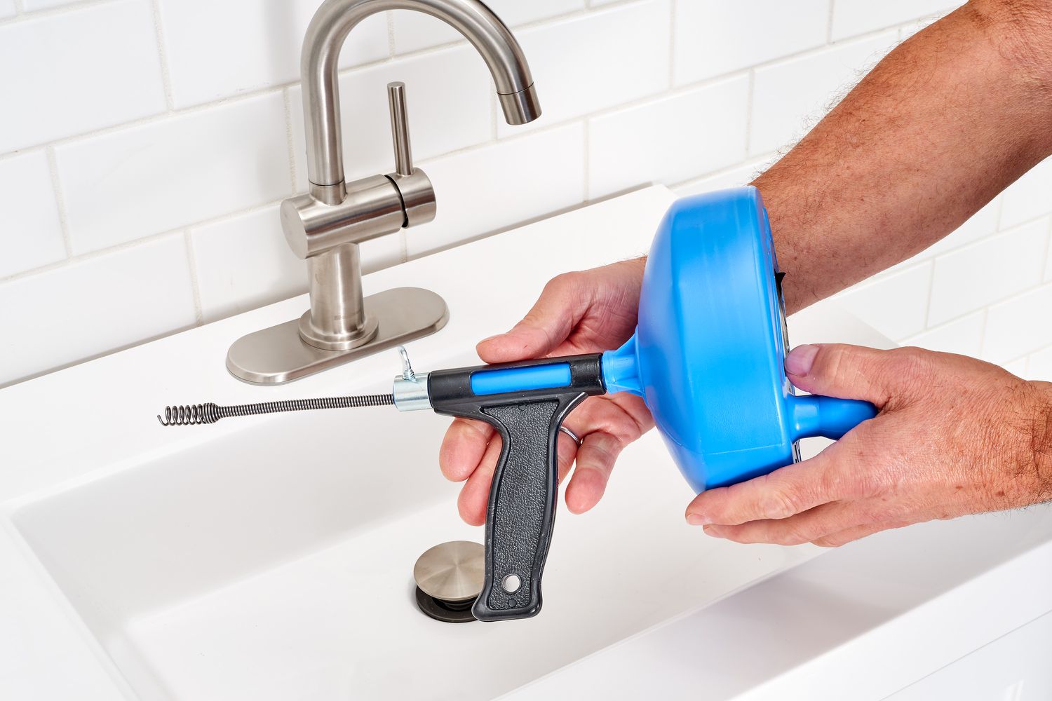 Drain snake held over sink