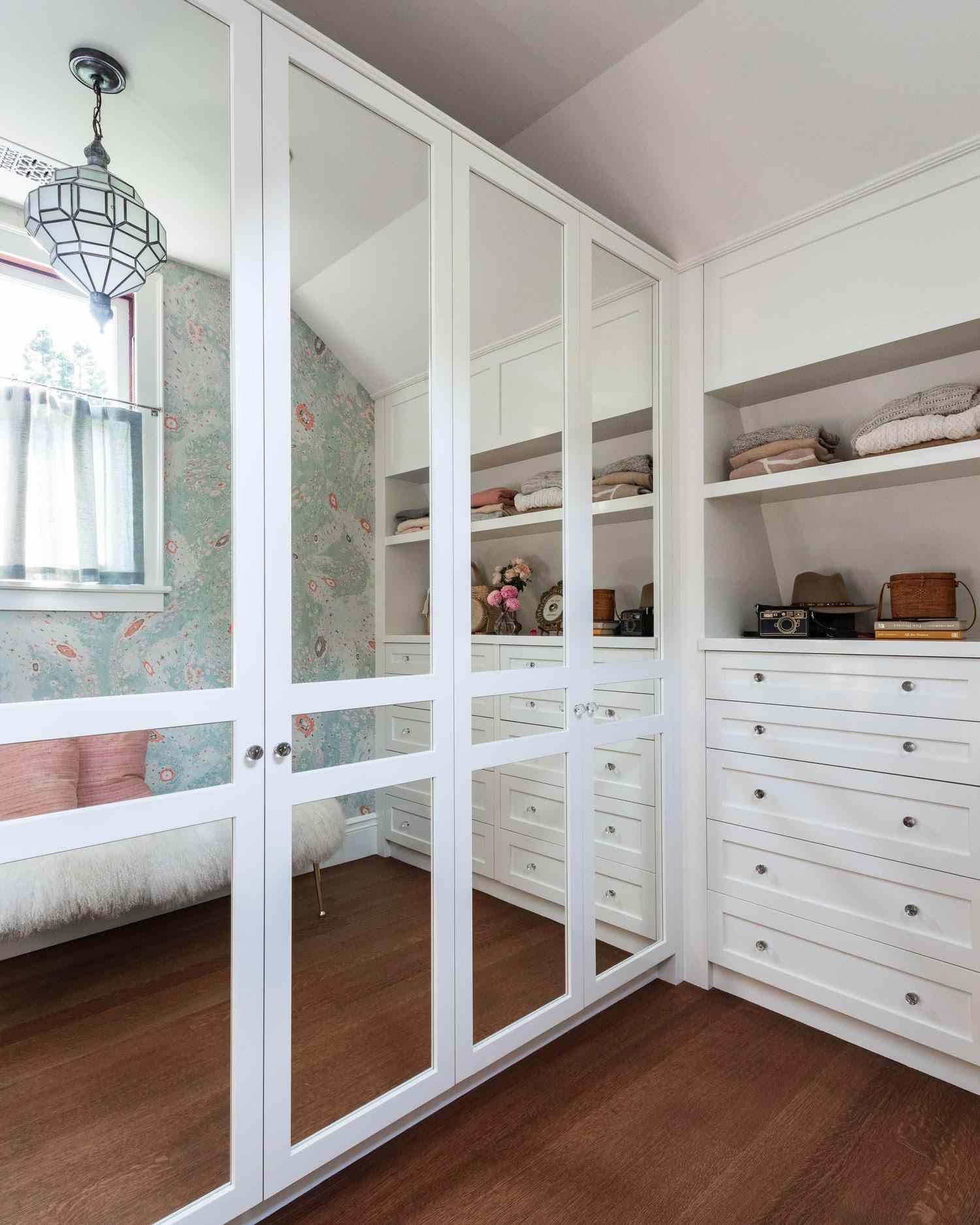 Armario con armarios empotrados blancos, armarios con espejos y techo inclinado