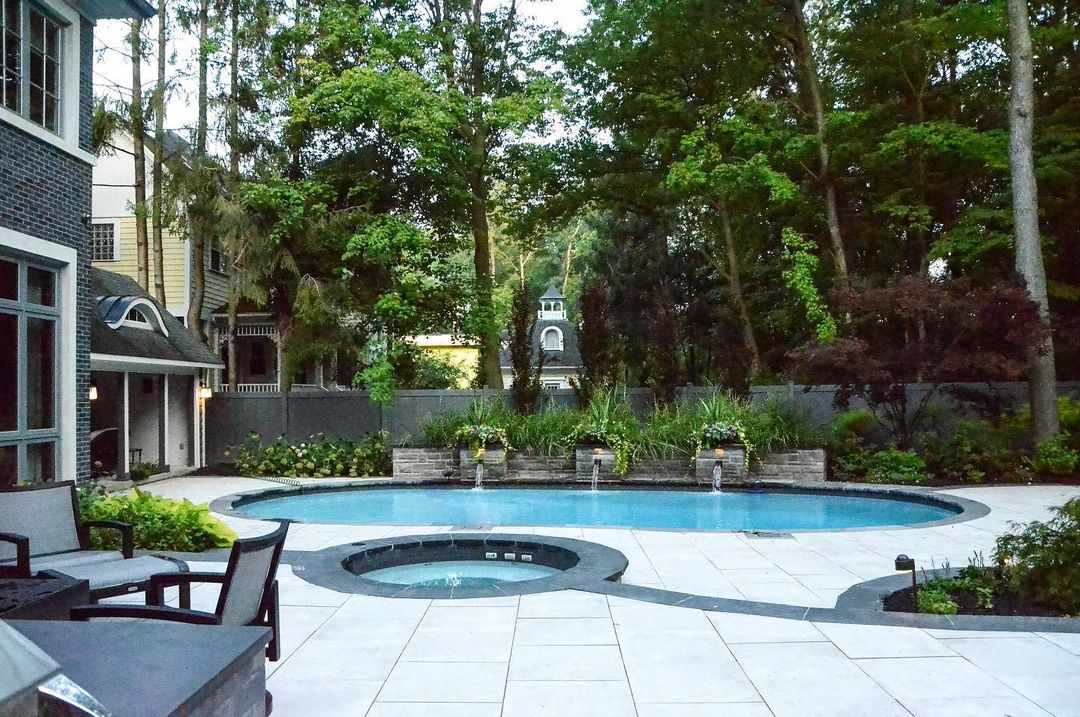 Ein Pool im Hinterhof mit schwarz-weißen Pflastersteinen