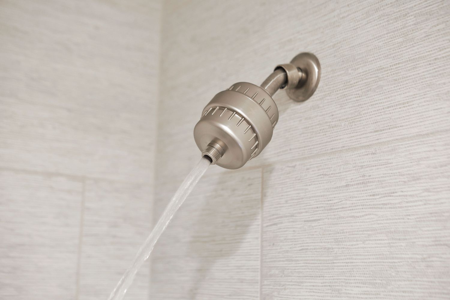 Water flushed through in-line shower filter to remove sediment