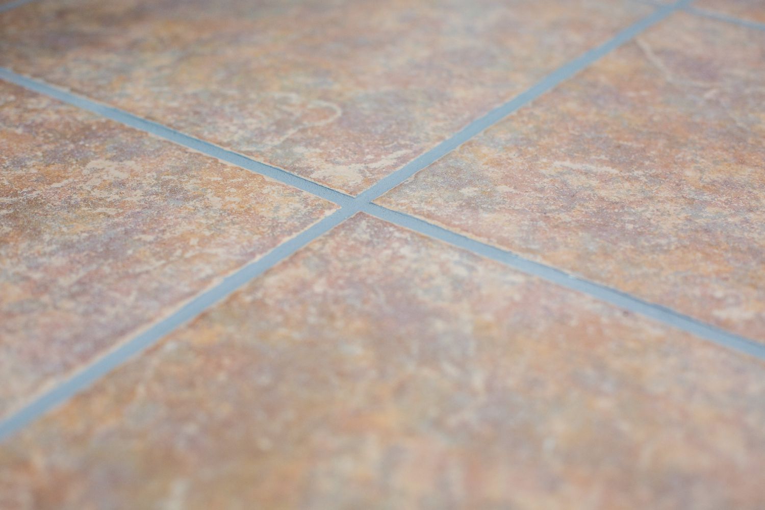 Newly applied grout colorant on brown tile air drying closeup