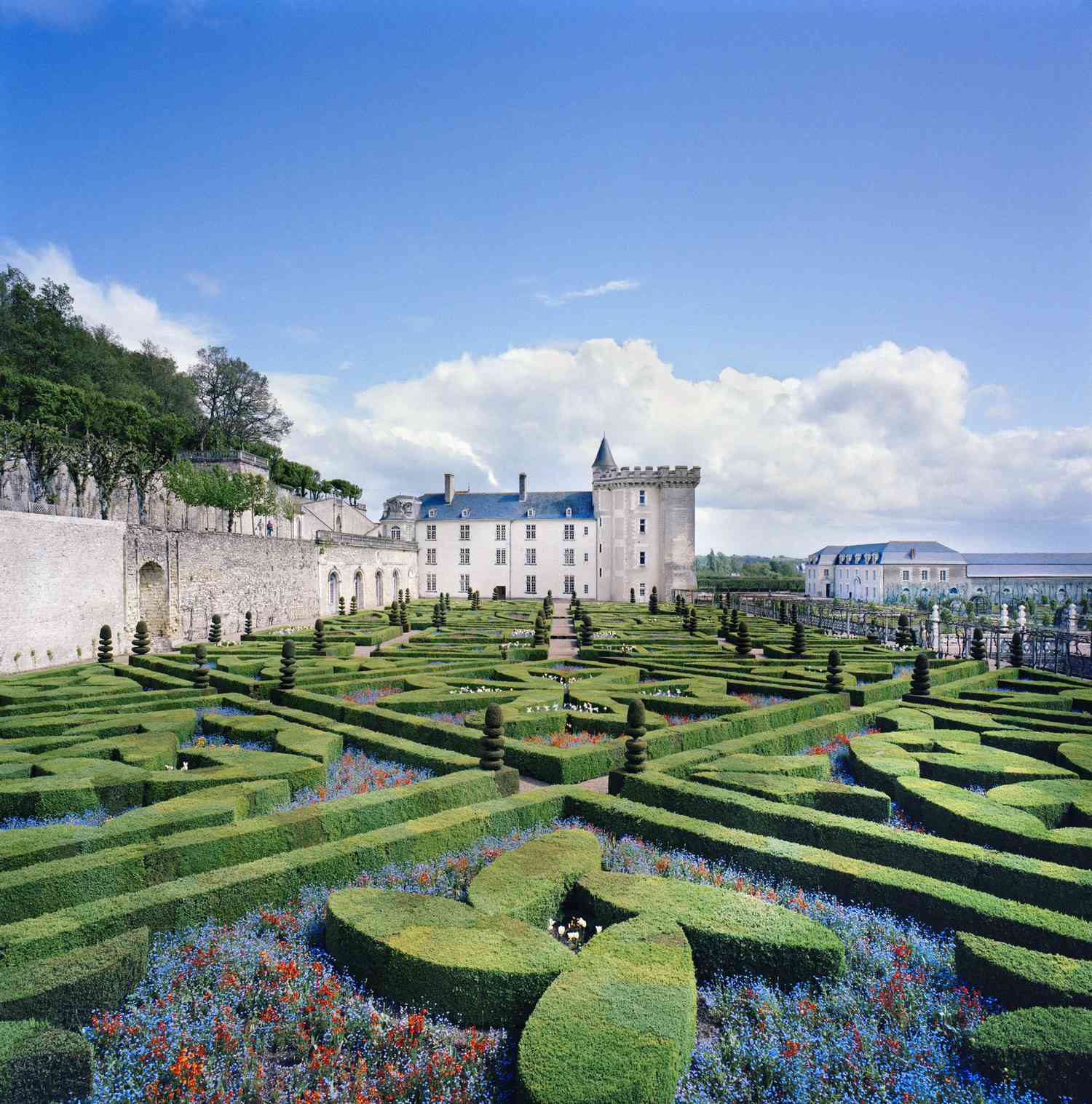 Un jardin français traditionnel avec des haies géométriques.