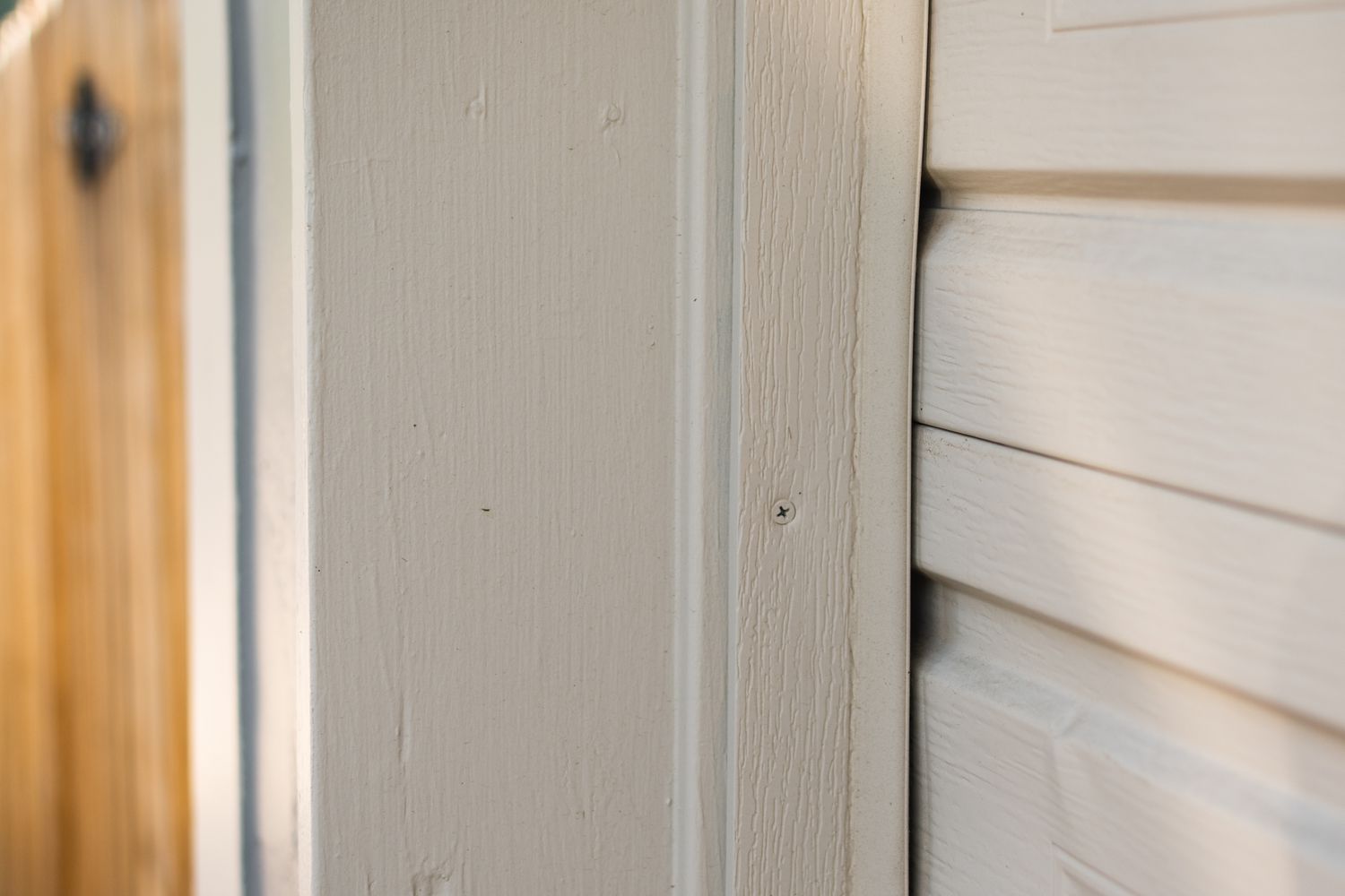 Puerta de garaje color hueso con burlete de vinilo instalado a la moldura lateral de la puerta de madera 