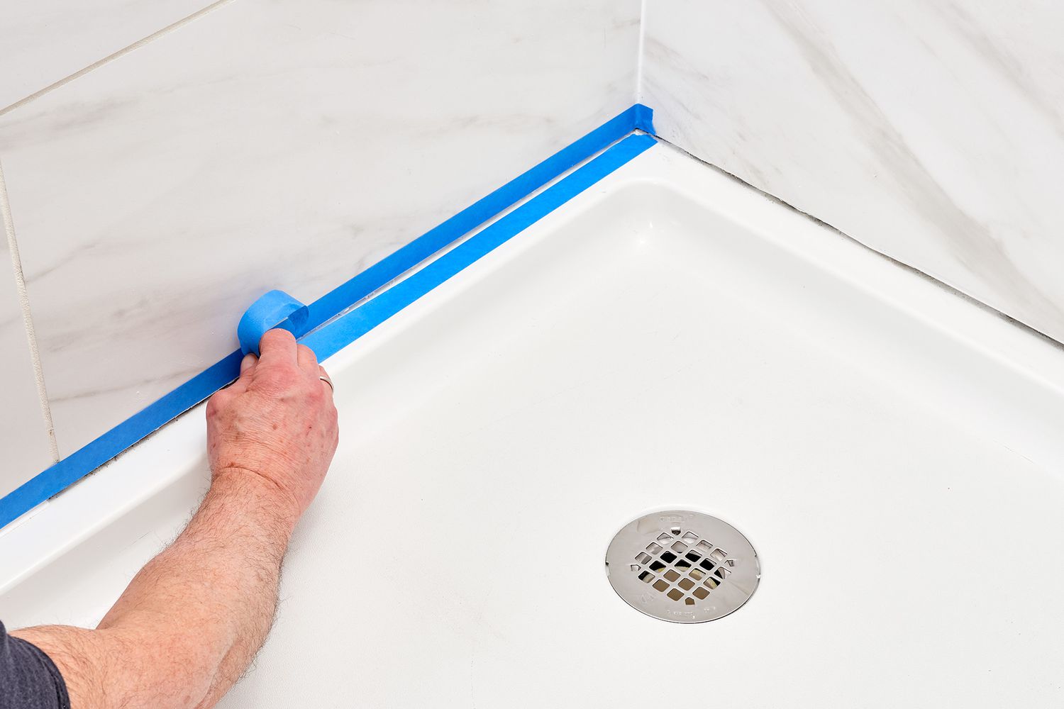 Painter's tape laid between shower wall and pan seams