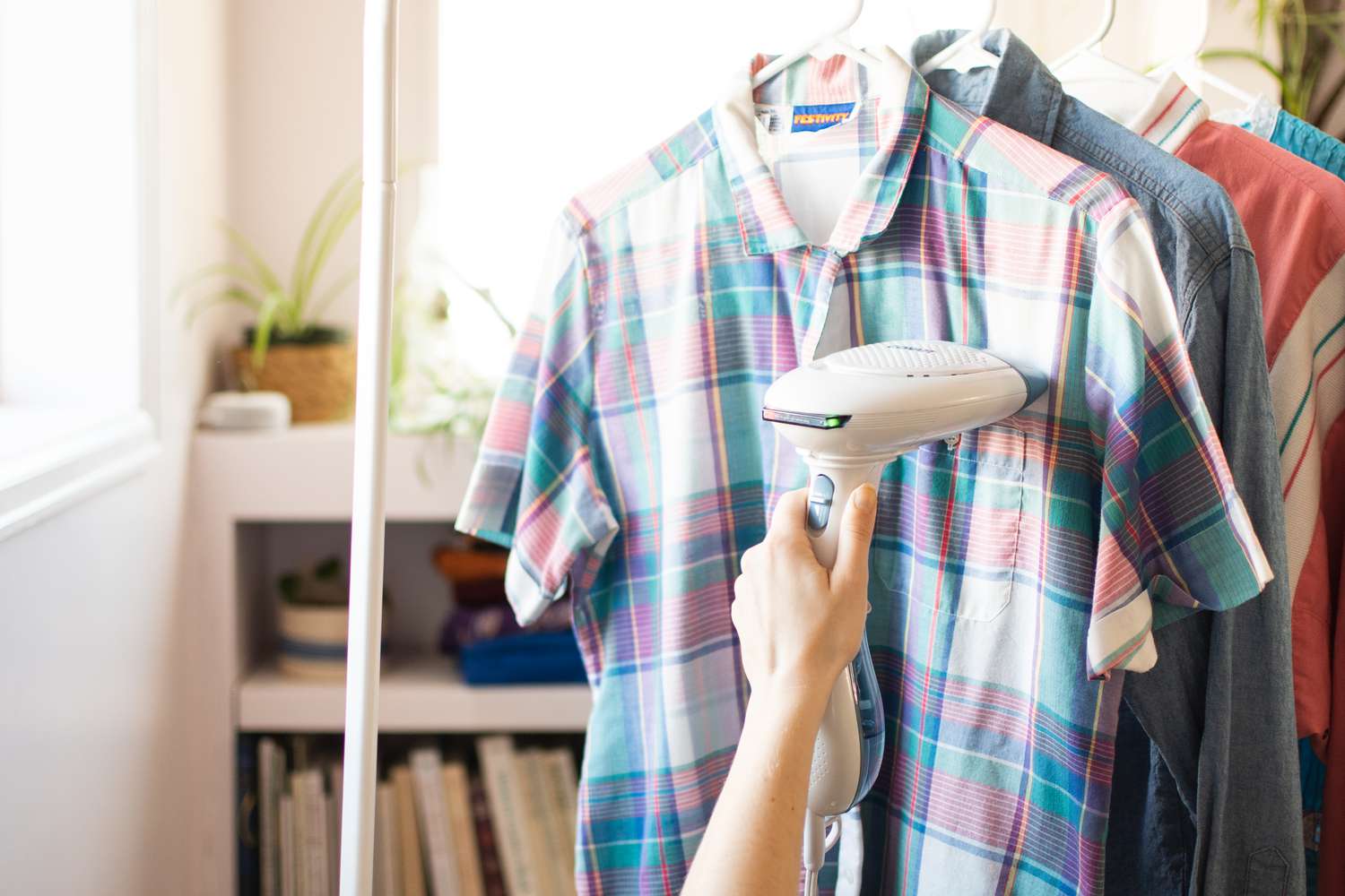 Clothes steamer taking out wrinkles on plaid shirt