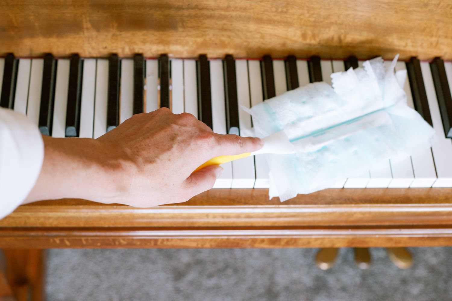 Quitar el polvo de las teclas de marfil de un piano