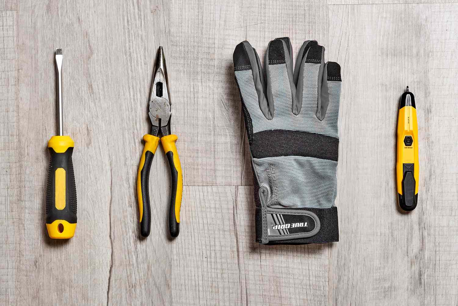 Tournevis plat, pince, gants de travail et testeur de tension pour changer une douille