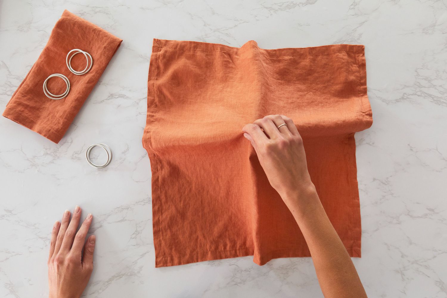 Orange cloth napkin laid flat and pulled up from center