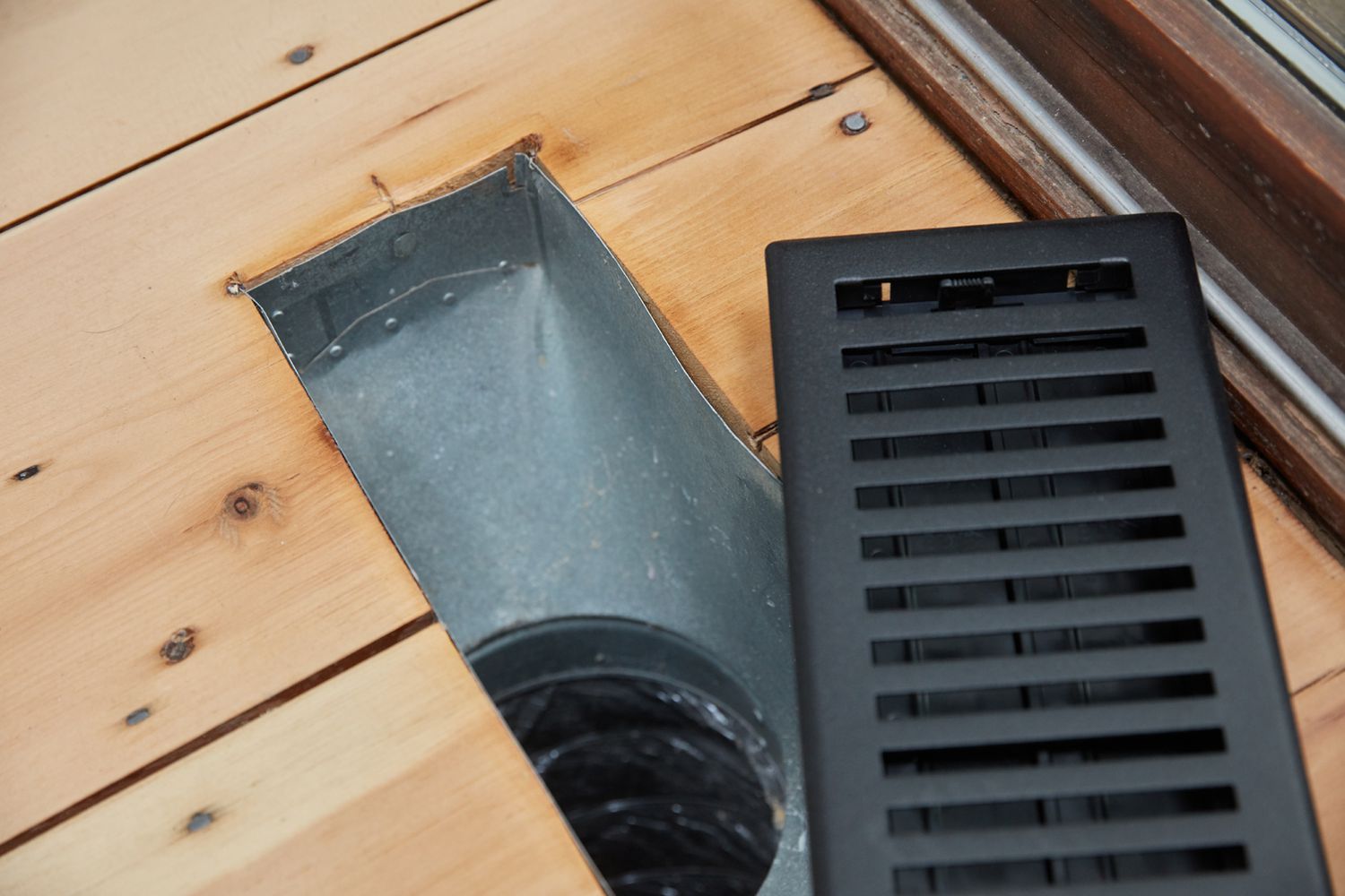 Exposed floor HVAC vent in wood flooring