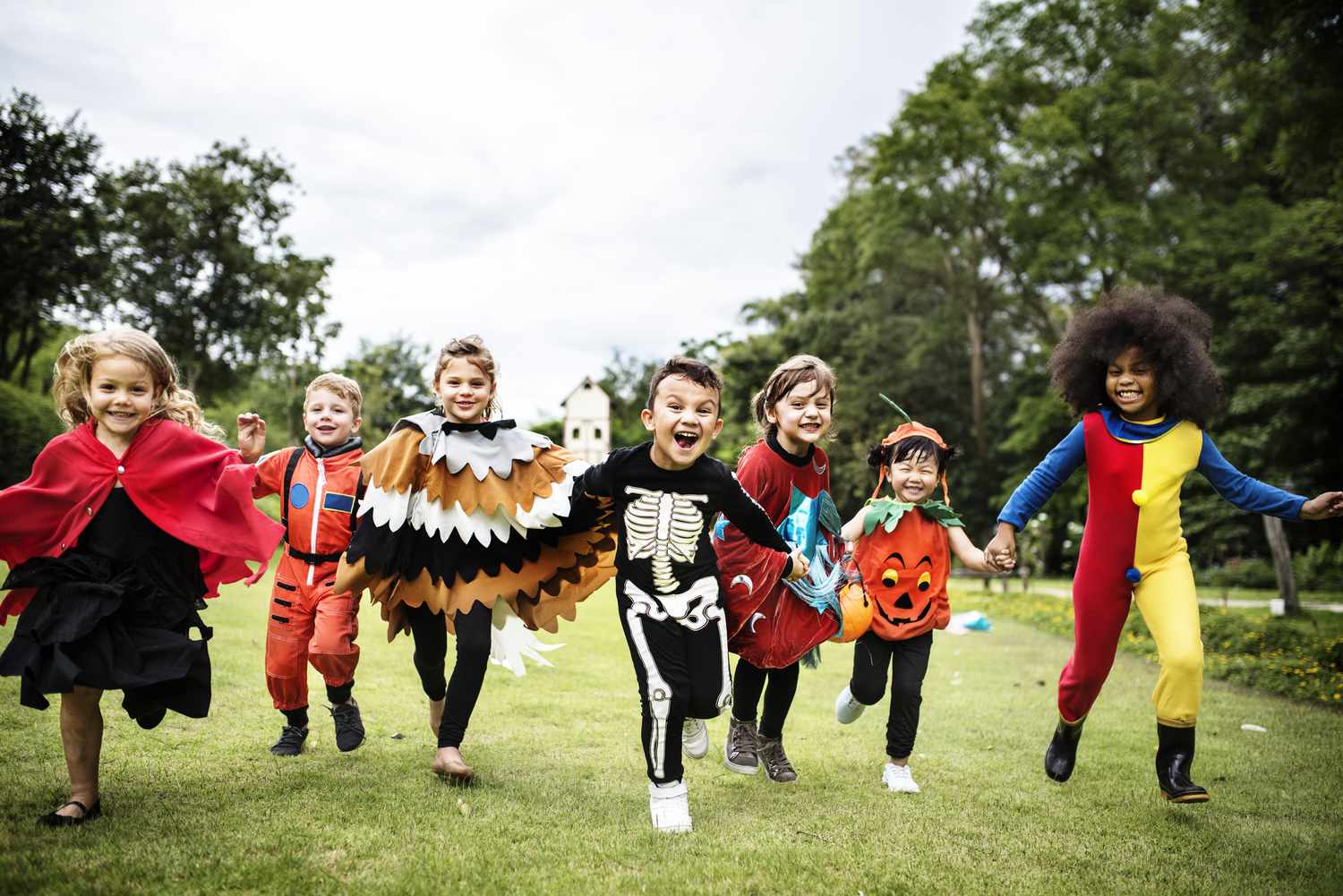 Kinder, die in ihren Halloween-Kostümen in einer Reihe laufen