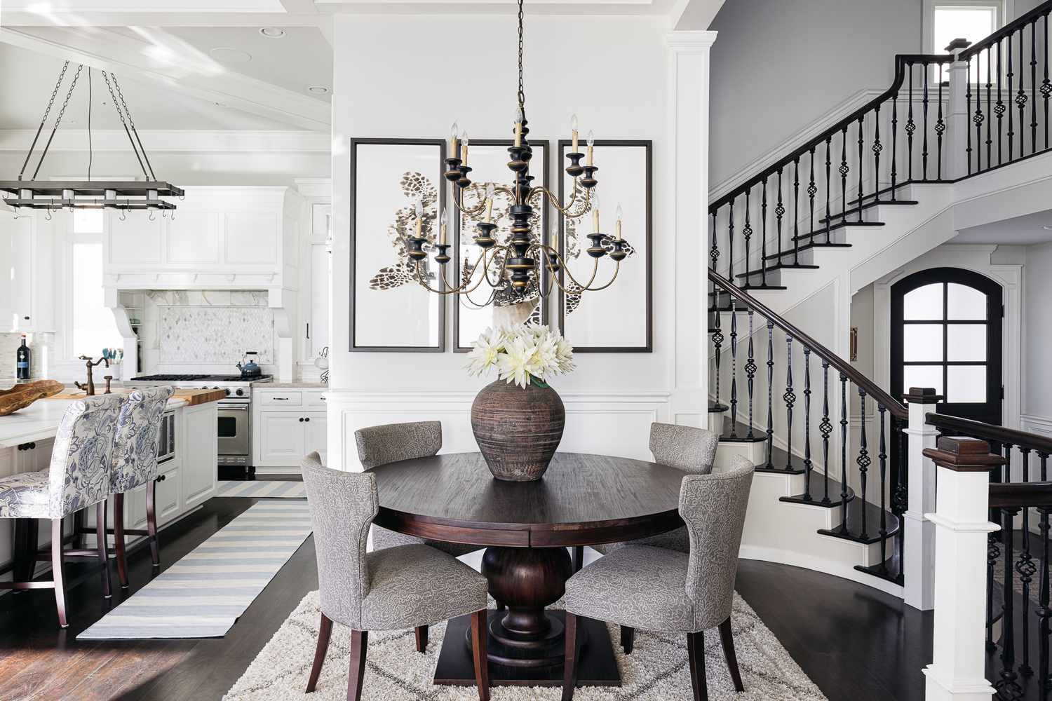 Mesa de comedor circular en medio de una casa monocromática en blanco y negro