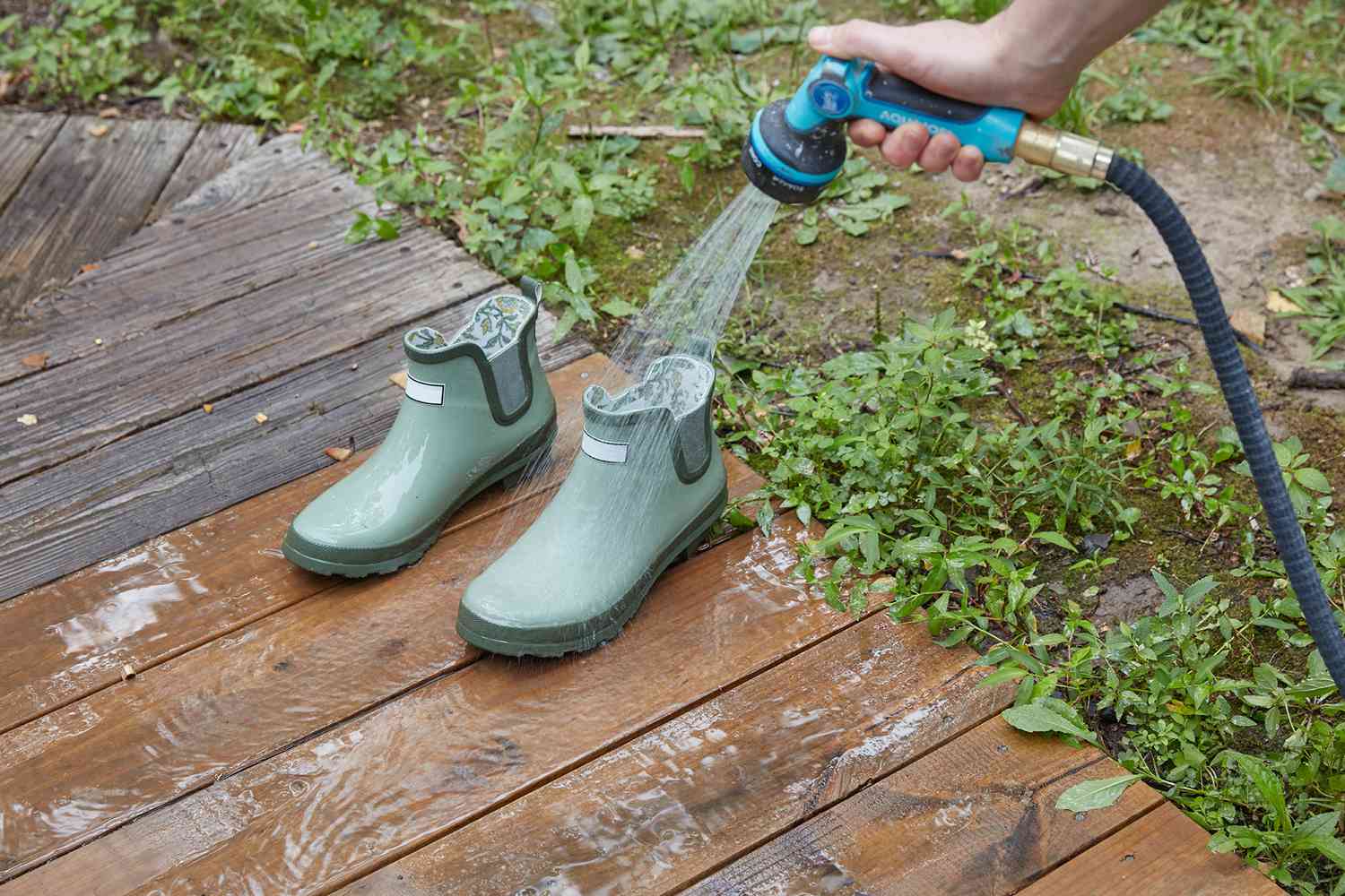 Gummigartenstiefel mit Seifenwasser aus dem Gartenschlauch gereinigt