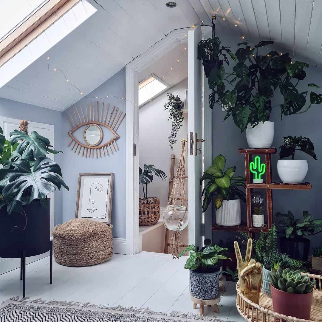 Room with slanted ceiling with lots of plants in it