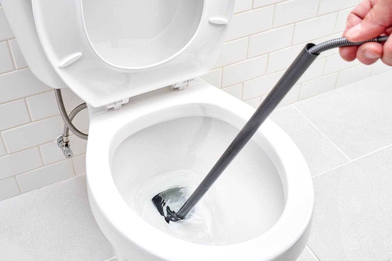 Toilet auger reaching inside toilet bowl